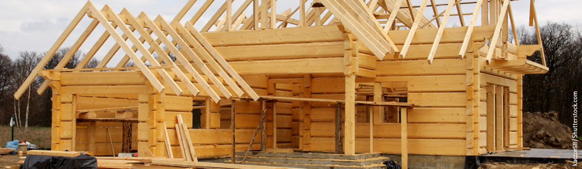 Holzhaus im Bau mit komplett stehenden Wänden und Dachaufbau